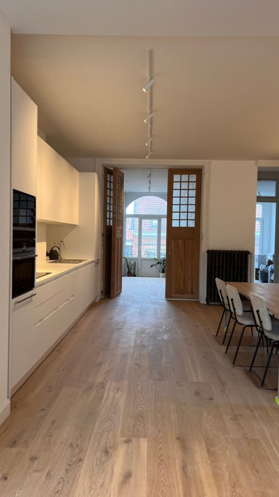 cuisine, plancher en bois et porte vers baie vitrée après une rénovation intérieure réalisée par MA-Intérieur