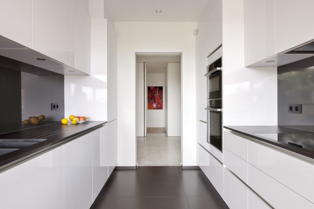 cuisine blanche ouvrant vers un couloir après une rénovation intérieure réalisée par MA-Intérieur